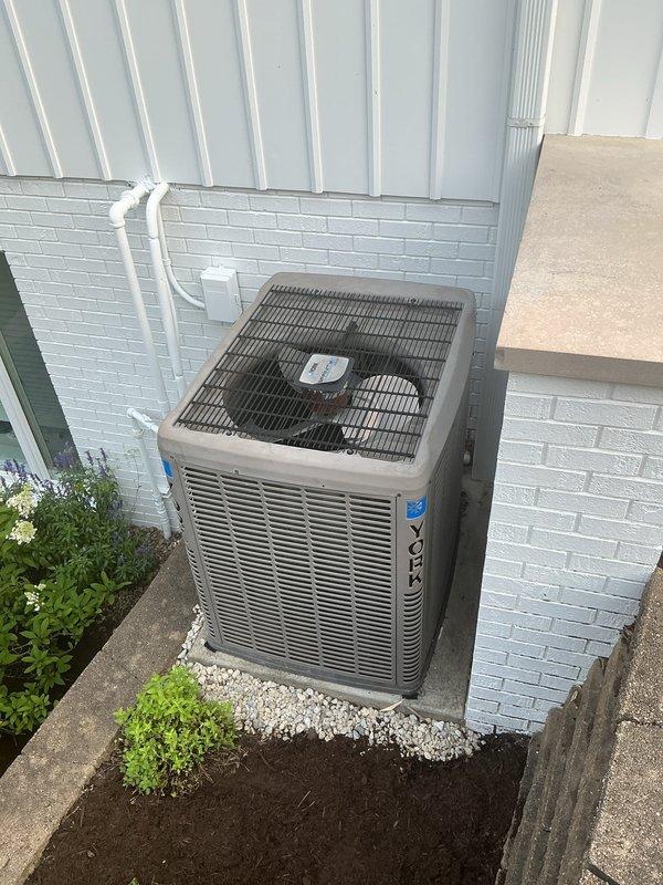 # HVAC Install - A/C & Coil

Completed full installation of new residential air conditioning system including outdoor condensing unit and indoor evaporator coil. Positioned outdoor unit on concrete pad against exterior wall with proper clearance for airflow and service access. Unit features protective top grille and horizontal louvers for optimal ventilation. Routed refrigerant lines and electrical connections between outdoor condenser and indoor air handler.

Installed indoor evaporator coil assembly integrated with existing furnace cabinet in mechanical room. Mounted Honeywell control system on wall for system operation and temperature management. Connected condensate drainage system using PVC piping with proper trap configuration to handle moisture removal. Installed circulator pump with associated plumbing connections including shut-off valves for system isolation and maintenance access.

Completed all refrigerant line connections using proper brazing techniques and insulation. Rou