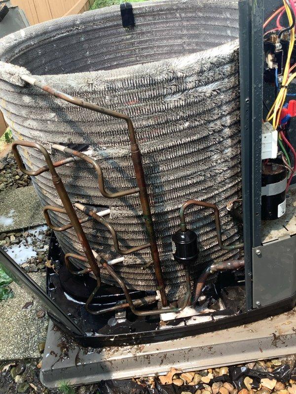 # Maintenance Service Completed on 13-Year-Old Air Conditioning System

Performed comprehensive preventive maintenance on a residential split-system air conditioner. Conducted thorough inspection of both indoor evaporator unit and outdoor condensing unit. 

## Indoor Unit Assessment

Accessed indoor air handler and inspected evaporator coil assembly. Found coil surfaces heavily contaminated with dust, dirt, and debris accumulation, significantly restricting airflow and reducing heat transfer efficiency. Examined refrigerant line connections and noted age-appropriate patina on copper tubing. Inspected filter drier and associated refrigerant piping for proper operation.

## Outdoor Unit Assessment

Inspected outdoor condensing unit and found condenser coil extensively clogged with lint, dust, and environmental debris, particularly concentrated in fin spaces and upper coil sections. Heavy contamination observed throughout coil surfaces, severely impacting unit performance and efficiency. 