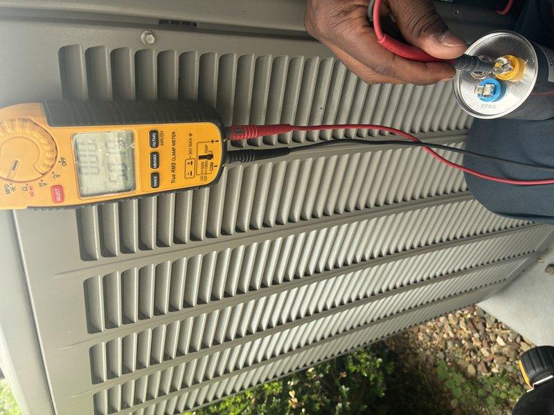 Completed MVP cooling maintenance visit on residential HVAC system. Performed electrical diagnostics on outdoor condenser unit, testing capacitor functionality with digital multimeter to verify proper operation. Inspected heat exchanger coil fins for cleanliness and airflow efficiency, finding them in good condition with uniform spacing. Examined control board wiring and connections, verifying all wire harnesses, terminals, and circuit board components were secure and functioning properly.