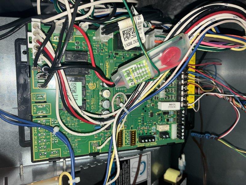 Completed MVP cooling maintenance visit on residential HVAC system. Performed electrical diagnostics on outdoor condenser unit, testing capacitor functionality with digital multimeter to verify proper operation. Inspected heat exchanger coil fins for cleanliness and airflow efficiency, finding them in good condition with uniform spacing. Examined control board wiring and connections, verifying all wire harnesses, terminals, and circuit board components were secure and functioning properly.