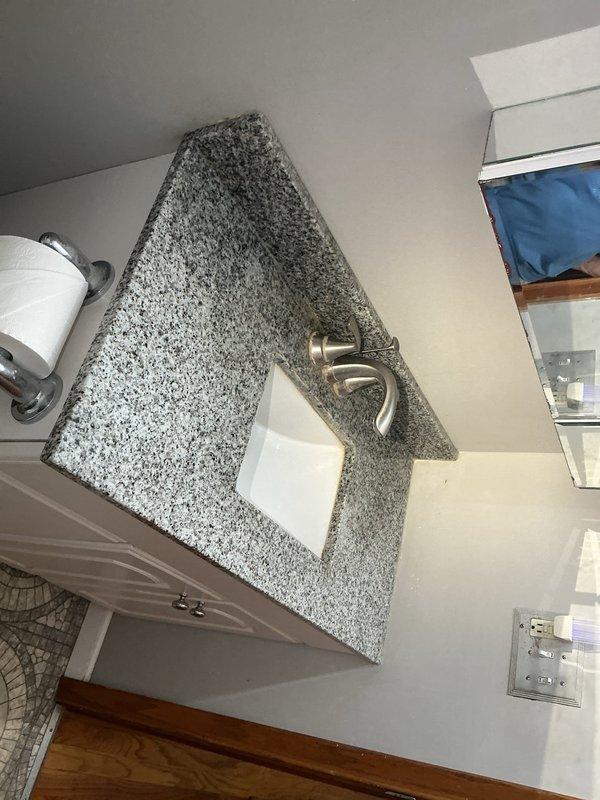 Installed new bathroom vanity countertop with integrated sink and modern single-handle faucet. Addressed slow drainage issues in both bathroom sink and bathtub drains to restore proper water flow.