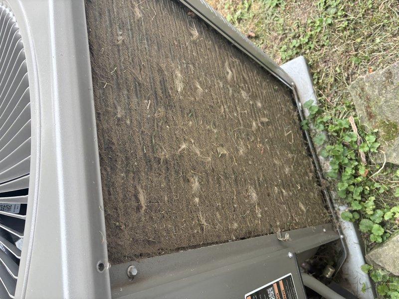 # HVAC Maintenance Summary

Completed scheduled BS-MVP cooling maintenance visit on residential air conditioning system. Upon arrival, contacted customer as requested and accessed outdoor condenser unit. Found extensive accumulation of dirt, debris, and organic material severely restricting airflow through condenser coils and air filter screen. Performed thorough cleaning of condenser coils to restore proper heat transfer efficiency. Removed and cleaned heavily soiled filter panel that was nearly completely obstructed with outdoor debris. Conducted system diagnostics and performance measurements to verify proper operation following maintenance. Documented pre- and post-service conditions with photographs showing significant contamination levels and completed cleaning work. Unit restored to optimal operating condition with improved airflow and heat exchange capacity.