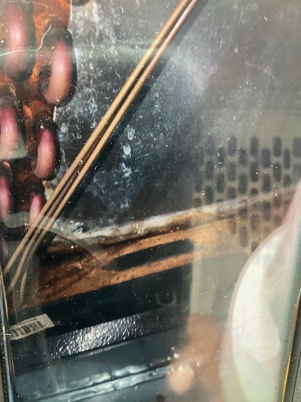 Completed routine maintenance on 19-year-old air conditioning system as part of recurring MVP cooling service. Inspected evaporator coil through access panel, noting condensation and dust accumulation on viewing surface, and evaluated air filter condition within the air handler unit, observing dust buildup on filter media and housing assembly.