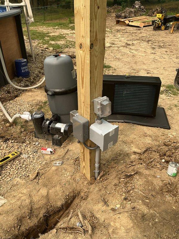 Installed complete electrical service for above-ground pool equipment including three GFCI-protected circuits from main panel: two 20-amp circuits for general use outlet and pool pump, and one 50-amp circuit for pool heater. Ran conduit down drywall with LB fitting to weatherproof junction box, converted to THHN wiring, and trenched underground line from house to pool equipment location. Installed vertical post with weatherproof junction boxes to isolate and distribute circuits to pump and heater. Completed all required pool bonding including skimmer, pump, heater, and copper bonding ring around pool perimeter per code requirements for composite pool structure.