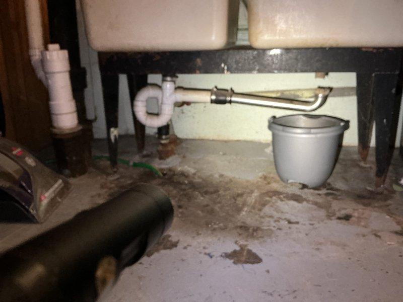 Responded to a laundry room wash sink drain backup causing water to leak onto the floor. Upon inspection, found the drain line beneath the sink was clogged with accumulated debris. Cleared the obstruction using a drain auger, restored proper drainage flow, and tested the system to ensure no further backup or leakage. Verified all P-trap connections were secure and functioning correctly.