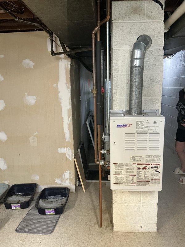 Responded to service call for intermittent operation of tankless water heater. Upon arrival, performed diagnostic assessment of the unit mounted in basement utility area. Inspected the tankless water heater system, including copper supply piping, gas connections, and exhaust venting. Evaluated electrical connections and control board functionality to identify cause of intermittent operation. Documented equipment condition through photographic record showing wall-mounted unit with proper venting configuration and associated plumbing connections. Diagnostic findings were reviewed and repair options presented for intermittent heating issue.