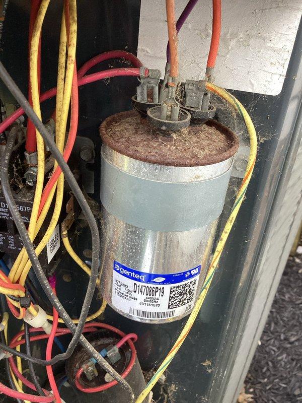 Responded to no cooling call on 11-year-old residential air conditioning system where indoor blower was operating but outdoor condensing unit failed to start. Upon inspection, diagnosed failed dual run capacitor in outdoor unit. Removed defective Genteq capacitor and installed new replacement capacitor with proper microfarad ratings for both compressor and condenser fan motor. Verified all electrical connections were secure, tested system operation, and confirmed outdoor unit now starting properly with normal cooling cycle restored to entire home.