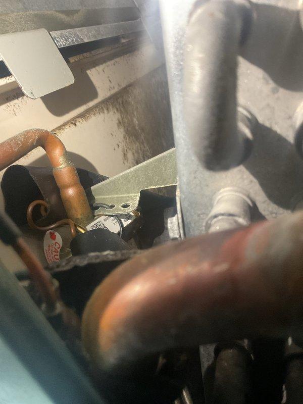 Completed MVP cooling maintenance visit on 11-year-old system. Performed comprehensive inspection of condensing unit, examining copper refrigerant lines showing normal age-related oxidation, verified capacitor condition and electrical connections, and assessed overall system operation. All components found functioning within normal parameters for unit age, with wiring and internal compartment showing typical wear consistent with years of service.