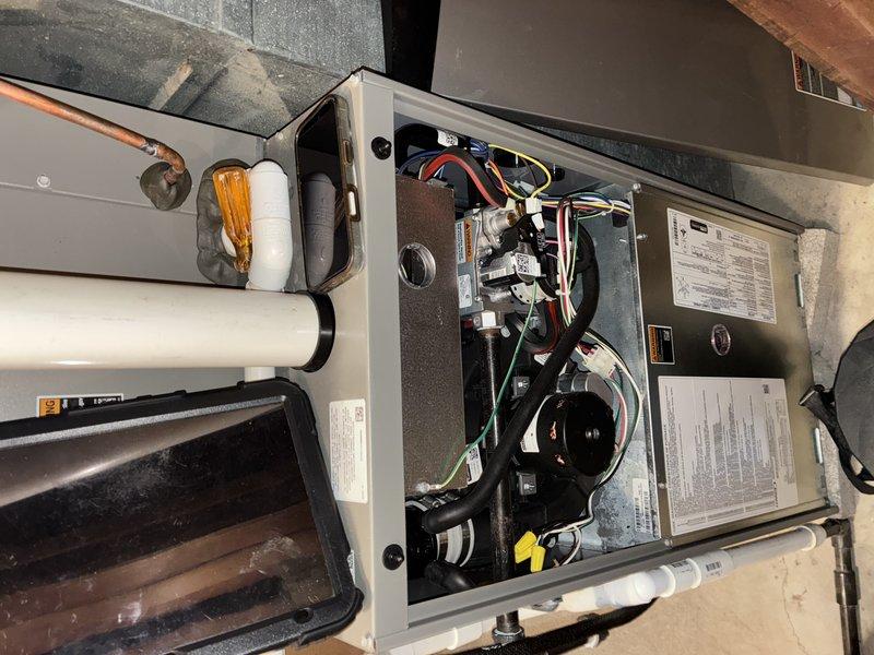 Completed MVP recurring cooling maintenance visit on 2-year-old HVAC system. Performed comprehensive inspection of indoor air handler unit, accessing internal components through service panel to evaluate blower motor assembly, electrical connections, refrigerant line connections, and condensate drainage system. Inspected control board for proper operation, verifying all wire harness connections secure and examining electronic components including capacitors and integrated circuits for signs of wear or failure. All colored wiring connections (red, black, yellow, green, blue, white, brown, pink) verified tight and properly seated in connectors. Evaluated PVC condensate piping routing and drain pan condition. System found to be in good operating condition with no visible signs of deterioration, rust, or component failure. Equipment appears well-maintained with clean internal components and proper installation in utility area.