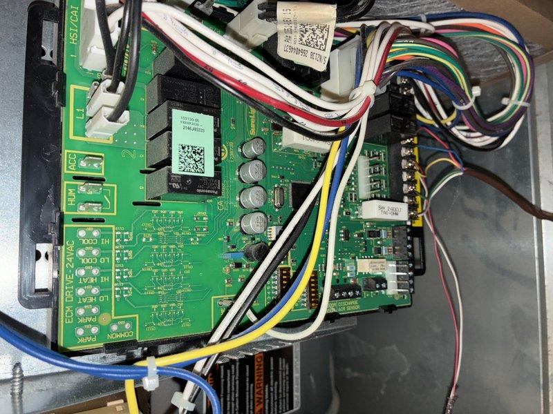 Completed MVP recurring cooling maintenance visit on 2-year-old HVAC system. Performed comprehensive inspection of indoor air handler unit, accessing internal components through service panel to evaluate blower motor assembly, electrical connections, refrigerant line connections, and condensate drainage system. Inspected control board for proper operation, verifying all wire harness connections secure and examining electronic components including capacitors and integrated circuits for signs of wear or failure. All colored wiring connections (red, black, yellow, green, blue, white, brown, pink) verified tight and properly seated in connectors. Evaluated PVC condensate piping routing and drain pan condition. System found to be in good operating condition with no visible signs of deterioration, rust, or component failure. Equipment appears well-maintained with clean internal components and proper installation in utility area.