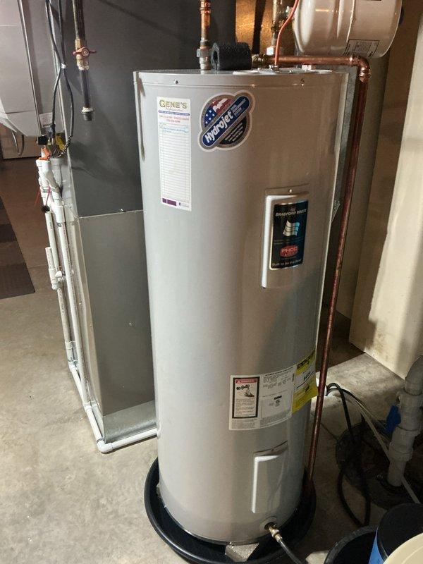 Responded to service call for leaking water heater valve on an 8-year-old Hydro+ tanked water heater unit. Upon inspection, identified active leak originating from valve assembly and confirmed existing drain pan beneath unit was cracked and required replacement. Documented installation with photographs showing copper supply lines, expansion tank, and current water heater configuration in mechanical room. Performed diagnostic assessment and provided repair recommendations to address valve leak and replace damaged drain pan to prevent potential water damage to flooring and surrounding area.