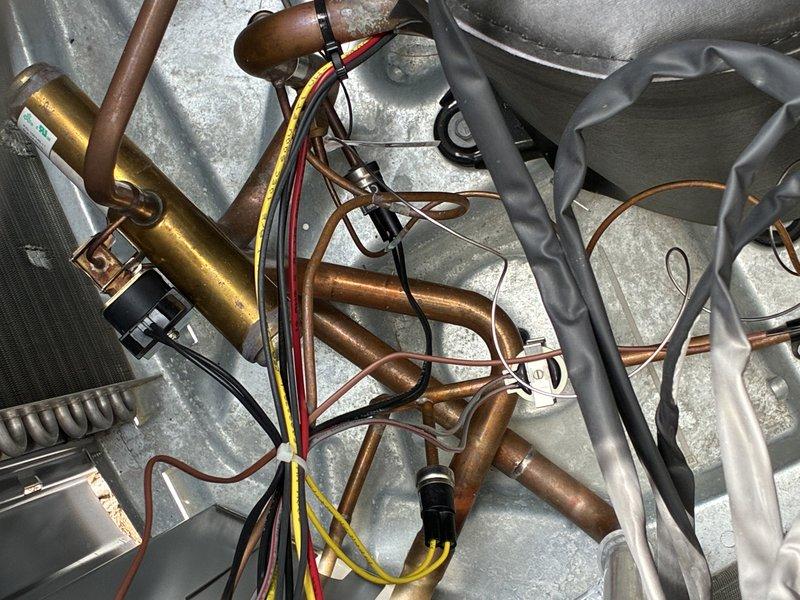 Responded to no-power condition on outside AC unit with tripped breaker that would not reset. Inspected electrical panel and identified tripped breaker serving outdoor condensing unit. Examined outdoor unit components including compressor, refrigerant lines, electrical connections, and condensate management system. Diagnosed short circuit condition preventing breaker reset. Traced fault to compromised wiring at unit connection point. Repaired damaged conductors, verified proper wire routing and connections, and restored secure terminations. Tested system for proper electrical draw and confirmed breaker held under load. Cycled unit multiple times to verify stable operation and proper amperage within manufacturer specifications. System restored to full operational status with no further tripping issues.