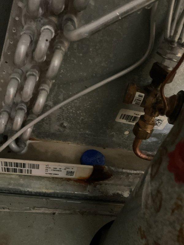 Responded to service call for non-operational air conditioning system approximately 20 years old. Upon arrival, performed comprehensive diagnostic evaluation of aging AC unit and associated components. Inspected evaporator coil assembly, refrigerant line set with U-bend configuration, and copper piping connections showing age-related patina and discoloration. Examined brass valves and fittings for proper operation and potential leak points. Assessed Trane gas furnace integration with cooling system, including ductwork connections and airflow pathways. System showed significant dust accumulation and normal operational wear consistent with two decades of service, requiring attention to maintain efficiency and reliability.