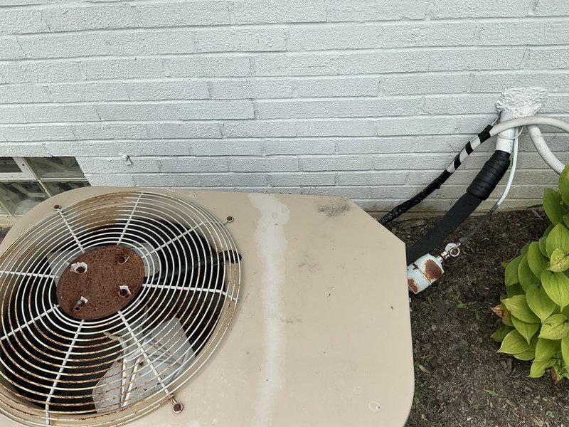 Completed on-site evaluation for furnace and air conditioning system replacement. Assessed existing outdoor condensing unit showing significant age-related deterioration, corrosion on fan assembly, and weathered cabinet condition. Inspected basement installation area with exposed ceiling joists and existing ductwork routing. Provided comprehensive replacement estimate for complete HVAC system upgrade including new furnace and air conditioning equipment.