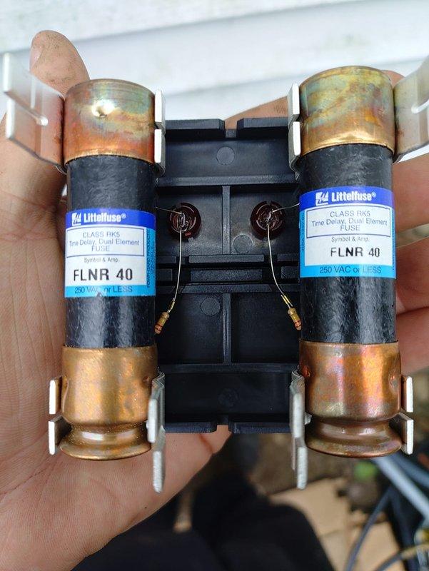 Completed installation of a complete HVAC system including 90% efficiency furnace, air conditioning unit, and humidifier. Replaced deteriorated dual-element time delay fuses (FLNR 40, 250V Class RK5) that exhibited significant oxidation and corrosion on the copper end caps, which could have caused electrical connectivity issues and system failures. Installed outdoor condensing unit at exterior foundation with proper electrical conduit routing from utility disconnect box through gray flexible conduit to ground level, ensuring code-compliant protection of wiring. All equipment tested and verified operational upon completion.