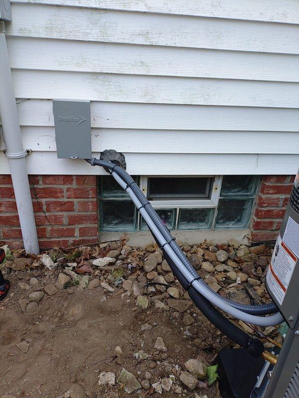 Completed installation of a complete HVAC system including 90% efficiency furnace, air conditioning unit, and humidifier. Replaced deteriorated dual-element time delay fuses (FLNR 40, 250V Class RK5) that exhibited significant oxidation and corrosion on the copper end caps, which could have caused electrical connectivity issues and system failures. Installed outdoor condensing unit at exterior foundation with proper electrical conduit routing from utility disconnect box through gray flexible conduit to ground level, ensuring code-compliant protection of wiring. All equipment tested and verified operational upon completion.