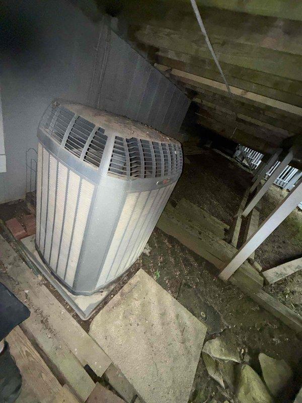 Completed routine maintenance visit on older residential air conditioning system located in attic space. Performed standard inspection of HVAC unit positioned on concrete platform, evaluating overall system condition and operation. Inspected and documented air filter status, noting moderate dust and particulate accumulation on pleated filter media requiring attention. Verified proper unit placement and surrounding structural conditions in attic environment. System assessed and documented photographically for maintenance records.