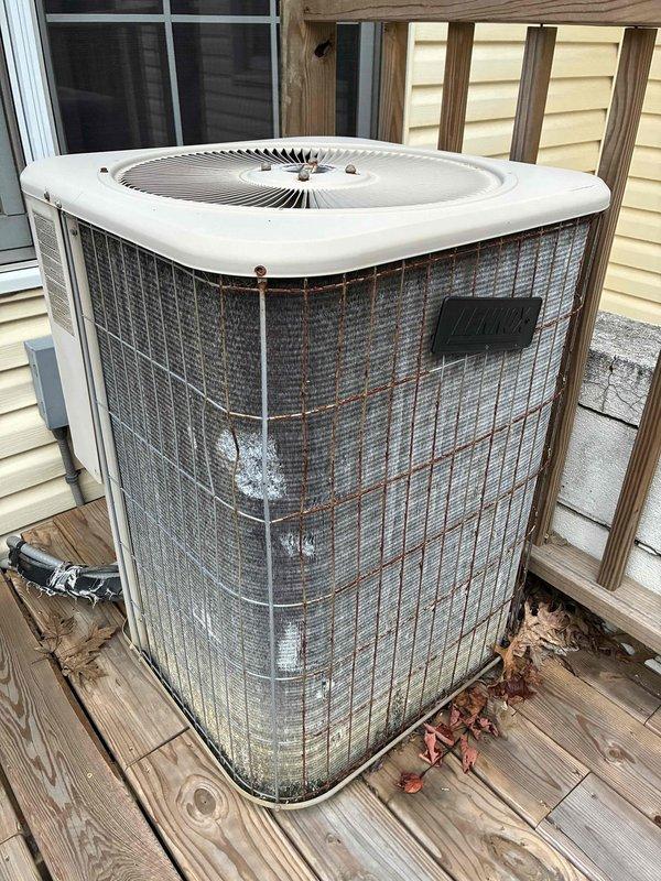 Performed routine maintenance on 26-year-old outdoor air conditioning condenser unit. Inspected electrical components including capacitor and contactor, which were found to be in functional condition despite unit's age. Removed accumulated debris, leaves, and organic matter from interior base and surrounding area. Noted significant rust staining on exterior mesh grille indicating weathering of protective coatings. Checked refrigerant lines and verified proper connections. System operating within normal parameters; no immediate repairs required at this time.