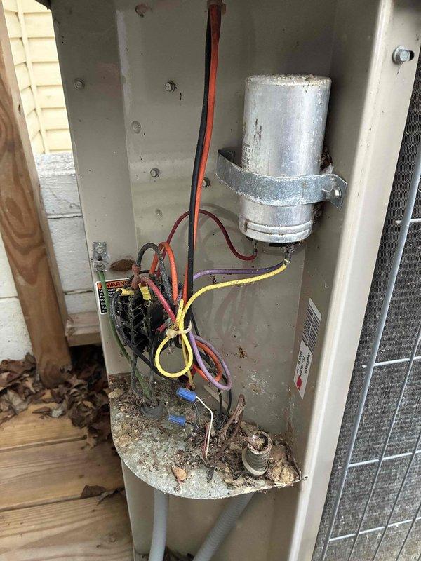 Performed routine maintenance on 26-year-old outdoor air conditioning condenser unit. Inspected electrical components including capacitor and contactor, which were found to be in functional condition despite unit's age. Removed accumulated debris, leaves, and organic matter from interior base and surrounding area. Noted significant rust staining on exterior mesh grille indicating weathering of protective coatings. Checked refrigerant lines and verified proper connections. System operating within normal parameters; no immediate repairs required at this time.