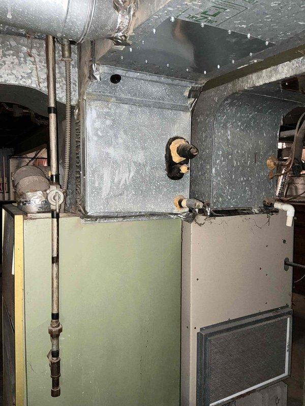 Performed site assessment for complete central air conditioning system replacement at residential property. Existing HVAC system is approximately 40 years old with aging air handler, ductwork, and associated components located in basement mechanical room. Documented current installation including metallic air handler unit with flexible ductwork, copper refrigerant lines, and electrical service panel configuration. Provided comprehensive estimate for new central air conditioning system installation.