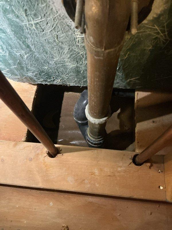 Responded to a service call for water leakage affecting the ceiling below a bathroom. Conducted diagnostic inspection of the shower/tub area and accessed the crawl space beneath to investigate potential leak sources. Examined vertical plumbing supply lines passing through the floor structure, including copper piping with brass fittings at penetration points. Inspected the bathtub drain assembly and water supply connections for signs of active leaks or moisture intrusion within the wall cavity and floor structure. Documented findings with photographs of the affected plumbing infrastructure and bathroom fixtures for further assessment and repair recommendations.