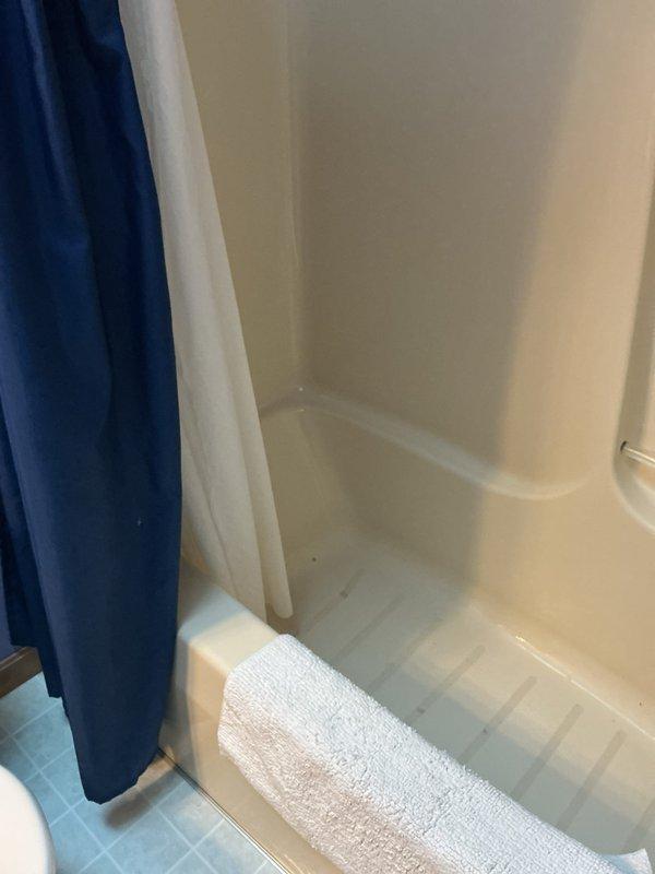 Responded to a service call for water leakage affecting the ceiling below a bathroom. Conducted diagnostic inspection of the shower/tub area and accessed the crawl space beneath to investigate potential leak sources. Examined vertical plumbing supply lines passing through the floor structure, including copper piping with brass fittings at penetration points. Inspected the bathtub drain assembly and water supply connections for signs of active leaks or moisture intrusion within the wall cavity and floor structure. Documented findings with photographs of the affected plumbing infrastructure and bathroom fixtures for further assessment and repair recommendations.