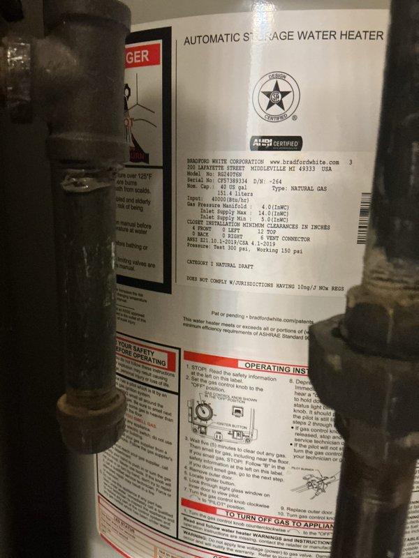 Replaced existing water heater with new Bradford White 40-gallon natural gas automatic storage water heater rated at 48,000 BTU/hr. Installed new ball valve and expansion tank while reusing existing water heater pan. Disassembled and reconfigured gas line to accommodate new unit, and modified furnace condensate line as needed for proper clearance. Relocated electrical switch adjacent to furnace to provide adequate space for new water heater installation. Placed bricks in pan to elevate unit and ensure proper combustion air clearance at base of water heater. Connected all copper supply lines and verified proper venting through existing ductwork. System tested and confirmed operational with all connections secure and no leaks detected.