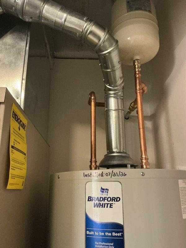 Replaced existing water heater with new Bradford White 40-gallon natural gas automatic storage water heater rated at 48,000 BTU/hr. Installed new ball valve and expansion tank while reusing existing water heater pan. Disassembled and reconfigured gas line to accommodate new unit, and modified furnace condensate line as needed for proper clearance. Relocated electrical switch adjacent to furnace to provide adequate space for new water heater installation. Placed bricks in pan to elevate unit and ensure proper combustion air clearance at base of water heater. Connected all copper supply lines and verified proper venting through existing ductwork. System tested and confirmed operational with all connections secure and no leaks detected.
