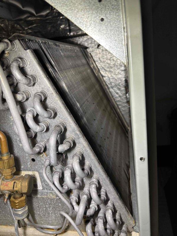 Completed comprehensive AC tune-up and preventative maintenance on a four-year-old cooling system for MVP member. Performed full system inspection including evaporator coil assessment, refrigerant line connections, and service valve examination. Observed dust and dirt accumulation on evaporator coil assembly and surrounding components, which is normal for system age and operation. Inspected air filtration system and noted heavily soiled pleated air filter requiring replacement. Verified refrigerant lines, brass fittings, and service valves showed no signs of leaks or degradation. System operational with no reported issues or symptoms prior to service call. All components functioning within normal parameters following maintenance procedures.
