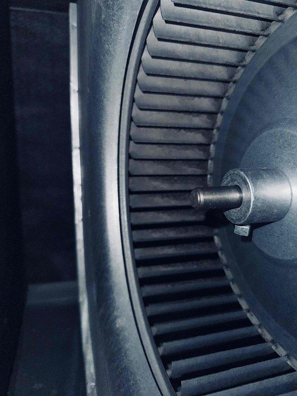 Completed comprehensive tune-up on air conditioning system over 20 years old. Performed electrical diagnostics using digital multimeter to verify system voltage and capacitance readings, with measurements indicating 8.99 units on primary circuit. Inspected blower wheel assembly and found light dust accumulation on blades but component remained in functional condition with proper blade spacing and shaft alignment intact.