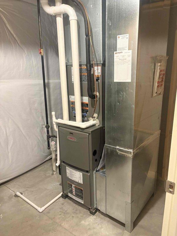Completed installation of new Lennox air conditioning system including indoor evaporator coil and outdoor condensing unit. Installed indoor coil assembly integrated with existing Lennox furnace in basement mechanical room, with proper refrigerant line sets routed alongside PVC condensate drainage and venting system. Mounted outdoor Lennox condenser unit on equipment pad with gravel base against exterior wall, installed electrical disconnect box, and established all necessary electrical connections. Verified proper refrigerant charge, tested system operation, and confirmed all components functioning within manufacturer specifications.