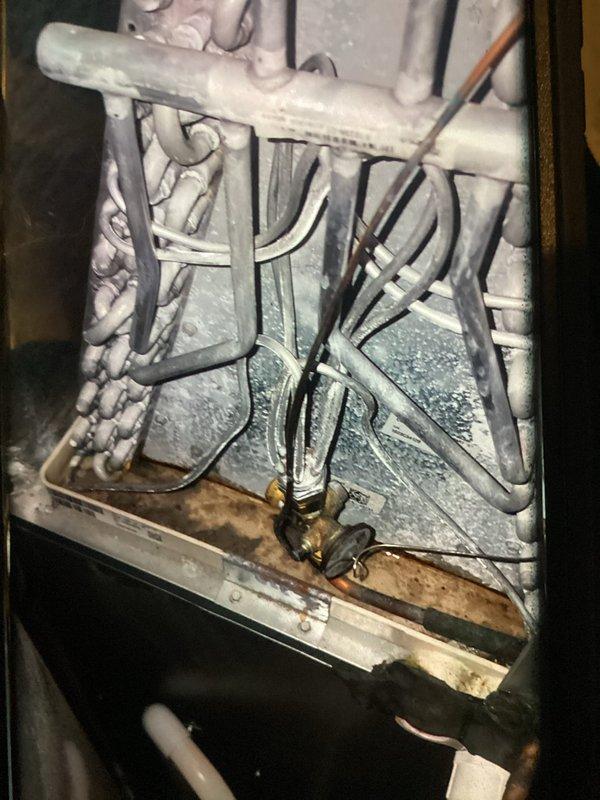 # HVAC Maintenance - Cooling Service

Completed MVP cooling maintenance visit on a 2-year-old Lennox heat pump system. Upon inspection of the indoor air handler, discovered extensive ice and frost buildup throughout the evaporator coil assembly, with crystalline frost completely covering the serpentine coil tubes and surrounding components. The frost accumulation was particularly dense on horizontal refrigerant lines and coiled sections, indicating a significant operational issue requiring immediate attention.

Investigated the root cause of the icing condition, which typically results from restricted airflow, low refrigerant charge, or system control malfunction. Allowed the system to thaw completely before proceeding with diagnostic testing. Inspected air filter condition, verified proper airflow across the evaporator coil, and checked all electrical connections and control wiring within the air handler cabinet. Examined the brass fittings and refrigerant line connections for signs o