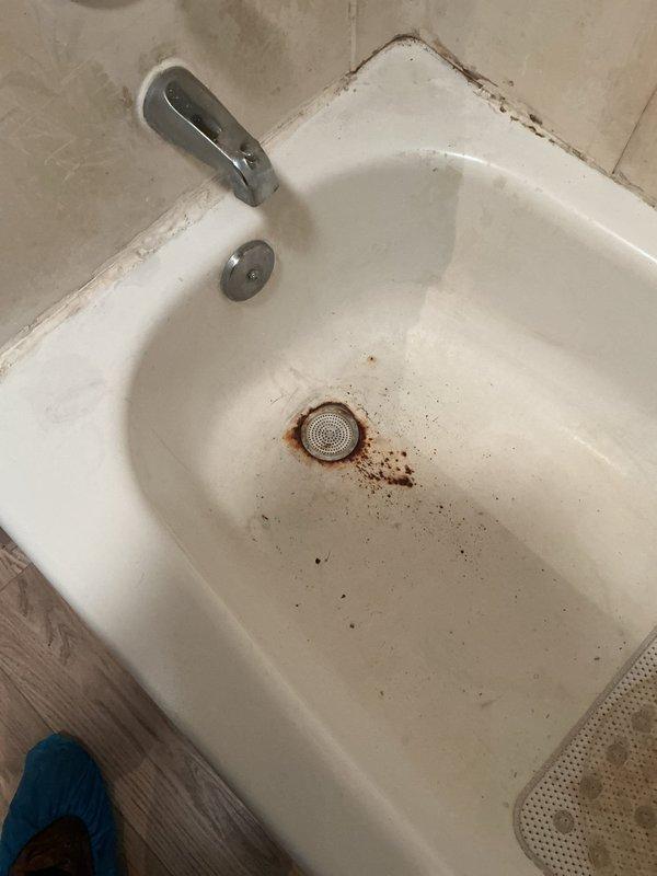 Responded to service call for bathtub replacement assessment and toilet evaluation. Inspected existing bathtub and documented significant deterioration including extensive rust staining around drain area, surface wear throughout porcelain basin, and mildew buildup along caulked seams where tub meets tile surround. Measured existing plumbing rough-in dimensions to determine specifications for new tub installation. Assessed toilet stability as requested and provided recommendations for complete bathroom renovation scope of work.