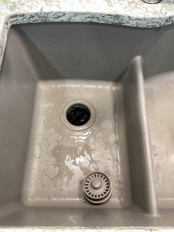Responded to service call for a 4-year-old garbage disposal unit reported to be struggling, with customer suspecting the wall switch as the cause. Upon arrival, performed diagnostic inspection of the disposal unit mounted beneath the kitchen sink. Examined electrical connections, tested wall switch functionality, and assessed the disposal motor and grinding mechanism. Inspected the complete under-sink plumbing assembly including the P-trap configuration, drain connections, and mounting hardware. Verified proper electrical supply to the unit and evaluated mechanical operation. Documented existing conditions including mineral deposit buildup around drain openings in the stainless steel sink basin. Completed troubleshooting procedures to identify the root cause of the disposal's performance issues.