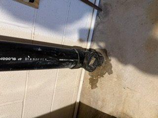 Responded to service call for water leak from tankless water heater piping and reported chemical odor in crawl space. Inspected recent copper piping and exhaust pipe rerouting installation. Documented deteriorated penetration points where black flexible exhaust ducting passes through wall surfaces, noting significant material degradation, brown staining, and compromised sealing around pipe penetrations that could allow moisture intrusion and potential fume migration into living space.