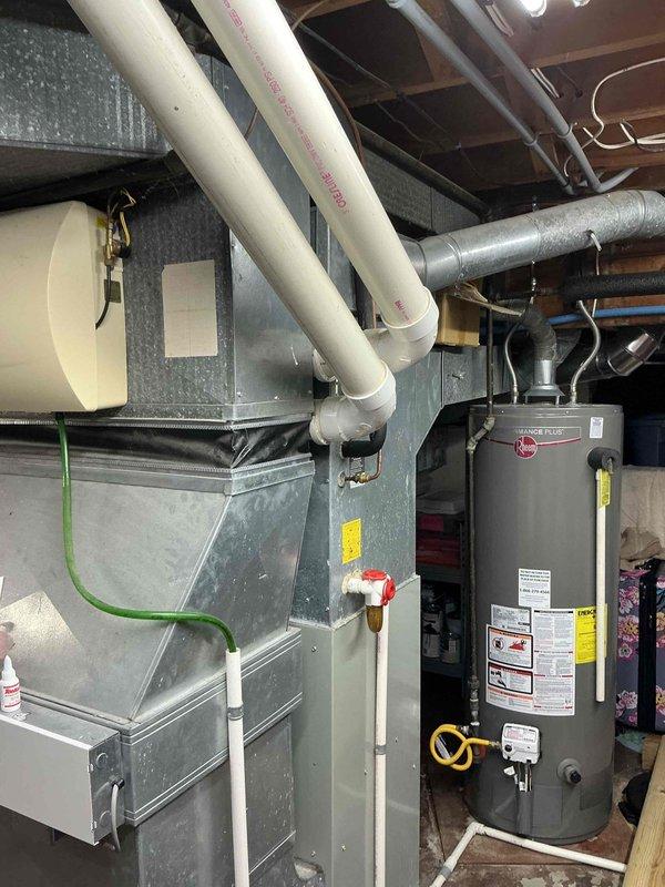 Conducted comprehensive assessment of 25-year-old HVAC system for complete replacement estimate. Inspected existing furnace, air conditioning unit, ductwork, and associated mechanical components in basement utility area. Documented current system configuration including air handler, galvanized metal ductwork, PVC drainage lines, and electrical connections. Photographed all equipment to provide detailed visual reference for replacement system specifications and installation planning.