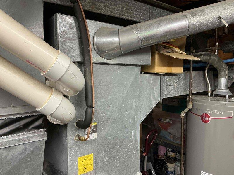 Conducted comprehensive assessment of 25-year-old HVAC system for complete replacement estimate. Inspected existing furnace, air conditioning unit, ductwork, and associated mechanical components in basement utility area. Documented current system configuration including air handler, galvanized metal ductwork, PVC drainage lines, and electrical connections. Photographed all equipment to provide detailed visual reference for replacement system specifications and installation planning.