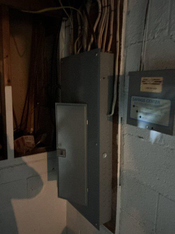 Conducted on-site evaluation of existing electrical service panel and grounding system for potential 200-amp service upgrade. Inspected aging electrical panel with visible rust staining and weathering, documented current service configuration including main breaker assembly and conduit connections. Assessed basement utility area electrical infrastructure, examined multiple panels and conduit routing to determine scope of work required for service upgrade and proper grounding installation.
