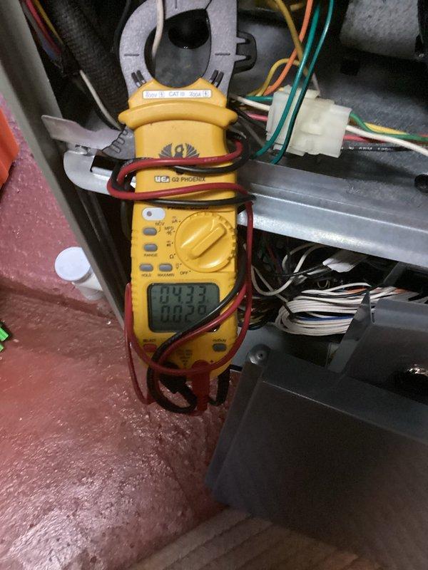 Completed MVP cooling maintenance visit on 13-year-old system that was rescheduled from previous date. Performed comprehensive system diagnostics including electrical measurements and refrigerant line inspection. Testing revealed normal operating parameters with multimeter readings of 04.33 on electrical components. Observed refrigerant piping showing age-appropriate wear with minor surface corrosion on suction line connections near red valve assembly. All measurements documented photographically for service records. System operating within acceptable range for unit age.