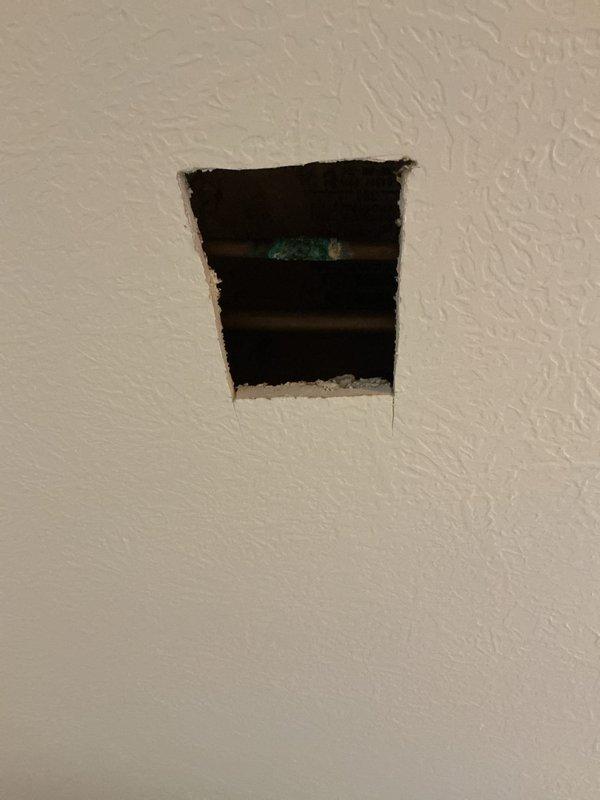 Responded to service call for corroded pipe in basement ceiling. Created access openings in ceiling and wall to locate and assess the deteriorated piping. Documented conditions with photographs showing extent of corrosion and access points required for repair work.