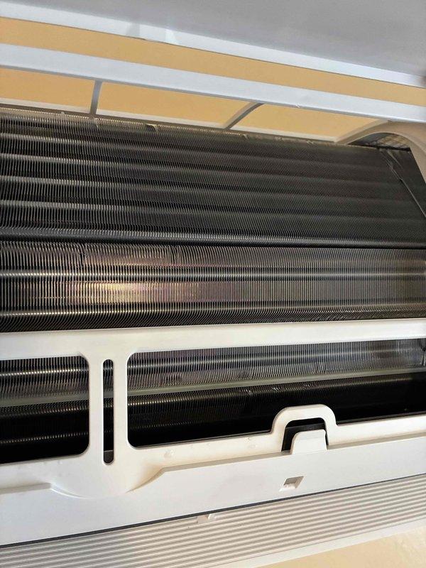 Completed preventive maintenance visit on one-year-old mini-split system located upstairs. Inspected both outdoor condenser unit and indoor wall-mounted air handler, finding accumulated debris, dust, and organic matter on outdoor coil fins and confirming indoor evaporator coils were in acceptable operating condition. Documented equipment condition with photos showing environmental buildup on outdoor unit requiring attention for optimal heat transfer efficiency.