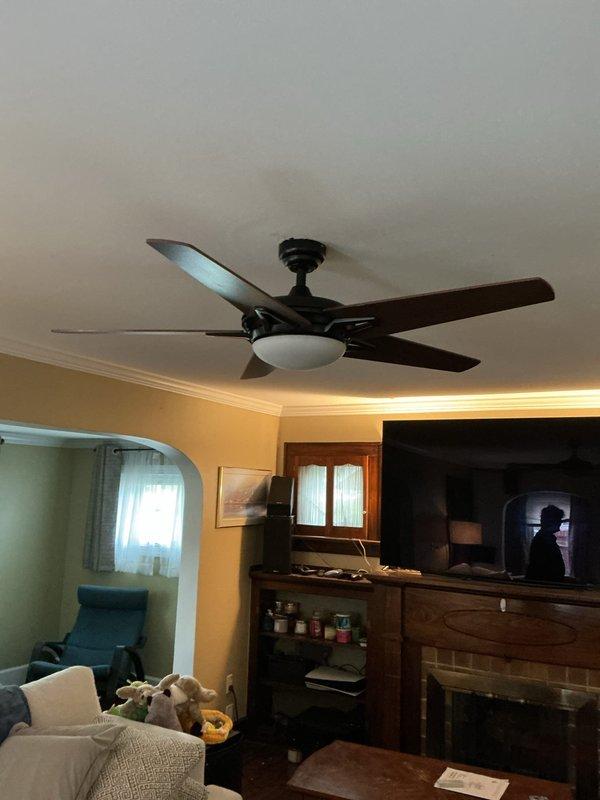 Installed two customer-supplied ceiling fans in the living room and upstairs office, replacing existing junction boxes with fan-rated support boxes to meet code requirements. In the living room, removed the existing dimmer switch and installed a single pole switch for proper fan operation. Due to the age of the home and plaster construction, exercised care during box removal and installation, noting potential absence of ground wiring in existing circuits. All installations completed with fan-rated hardware to ensure structural integrity and safety compliance.
