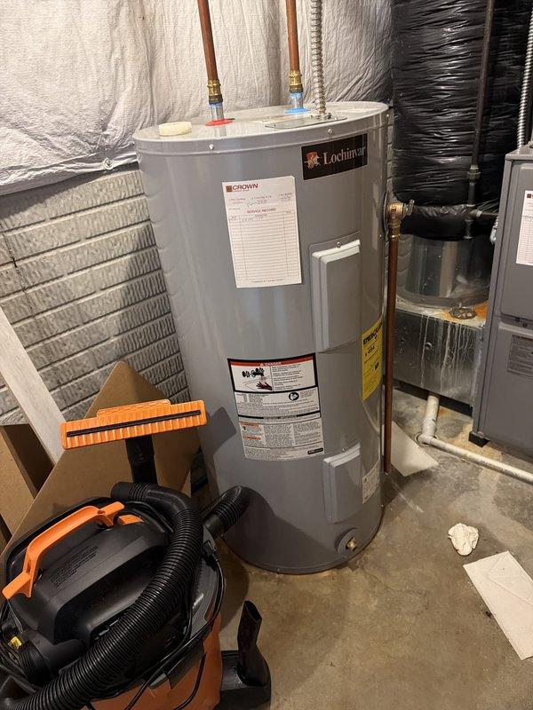 Responded to water heater service call at residential property. Upon arrival, inspected Lochinvar brand tanked water heater, approximately two years and nine months old based on manufacture date. Unit located in basement utility area with standard copper supply line connections and proper venting configuration.

Removed top access panel to assess internal components and heating elements. Inspection revealed significant sediment accumulation and corrosion deposits around heating element assembly and within tank opening. Brown discoloration present on internal foam insulation indicating mineral buildup from water quality issues. Multiple wire connections to heating element showed signs of exposure to moisture and sediment.

Documented unit condition with photographs showing overall installation and internal component deterioration. Verified warranty status with homeowner, who indicated he is second owner of property. Based on manufacture date and typical warranty terms, discussed coverag