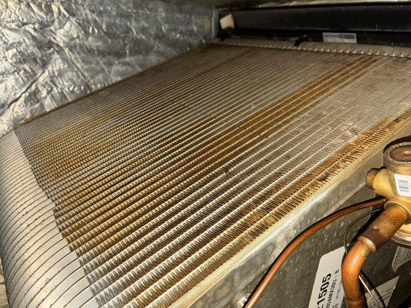 Completed preventive maintenance inspection on air conditioning system. Inspected and documented evaporator coil condition, which appeared clean with proper airflow through fins. Examined electrical components including dual fuse assembly with resistors and verified proper connections at refrigerant line entry points.