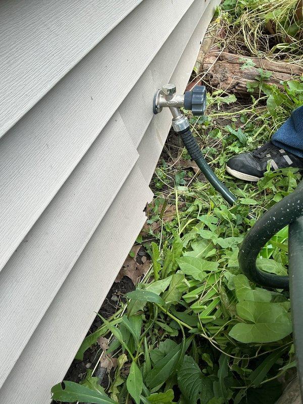 Responded to service call for leaking exterior hose bib. Upon inspection, found corroded brass valve body with compromised seal causing active water leakage at the foundation level. Replaced deteriorated hose bib assembly with new frost-free sillcock, ensuring proper pitch for drainage and secure mounting to exterior wall framing through vinyl siding. Tested valve operation and verified complete seal with no residual leakage upon completion.