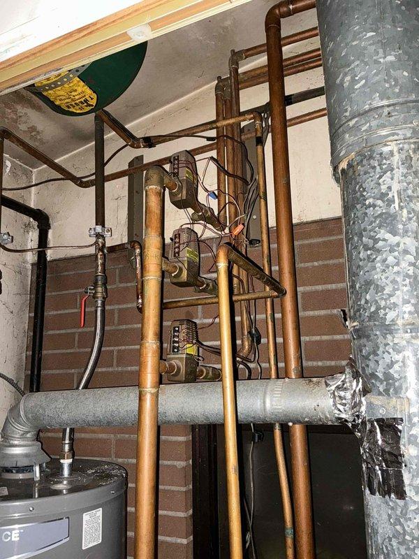 Conducted estimate for replacement of existing gas boiler system showing significant age and deterioration, including heavily rusted components and weathered ductwork connections. Assessment confirmed boiler replacement needed in current location without relocation, with existing copper piping infrastructure and gas lines to remain in place for connection to new unit.