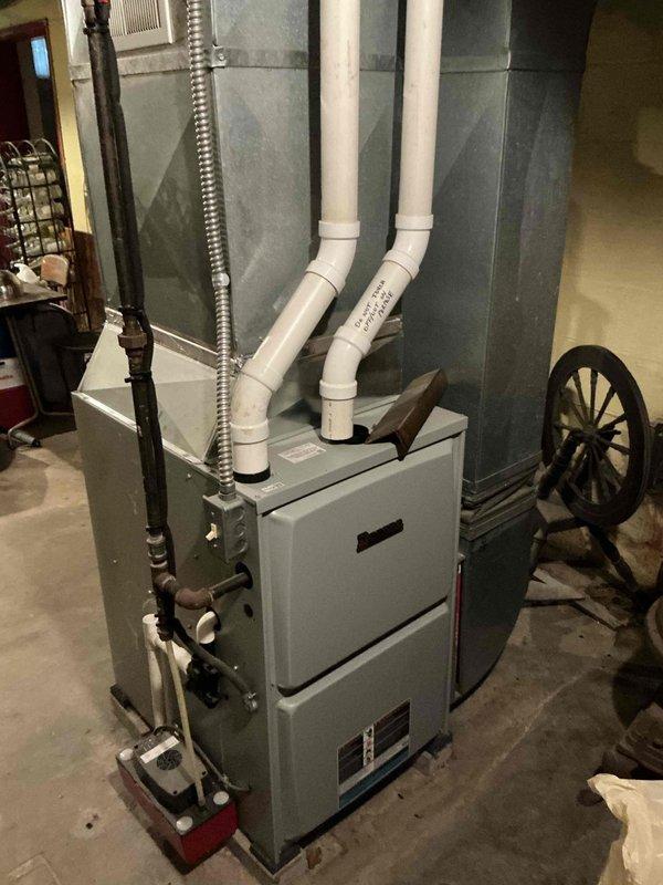 Conducted on-site evaluation for central air conditioning installation in small 3-bedroom residential property with existing Allied furnace and ductwork system. Assessed basement mechanical room containing recently installed furnace unit with proper PVC intake/exhaust venting, verified existing duct infrastructure compatibility, and documented current HVAC configuration including condensate pump and drainage components to provide comprehensive system replacement estimate.