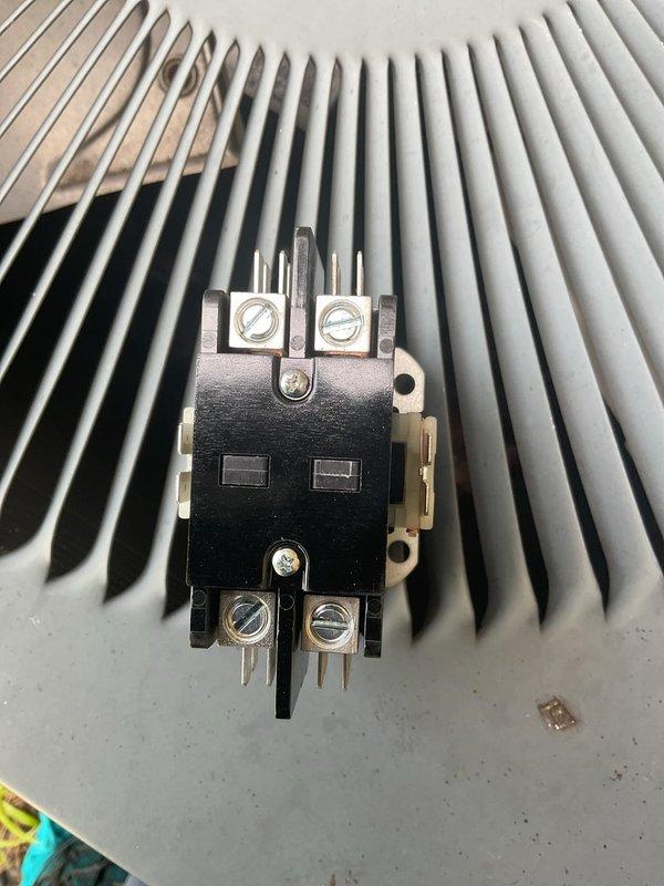 Responded to no cooling complaint on 13-year-old outdoor A/C unit where condenser fan was running but system not cooling. Diagnosed failed contactor preventing compressor operation. Replaced defective contactor with new unit, restored power to compressor, and verified proper system operation with all components functioning correctly.