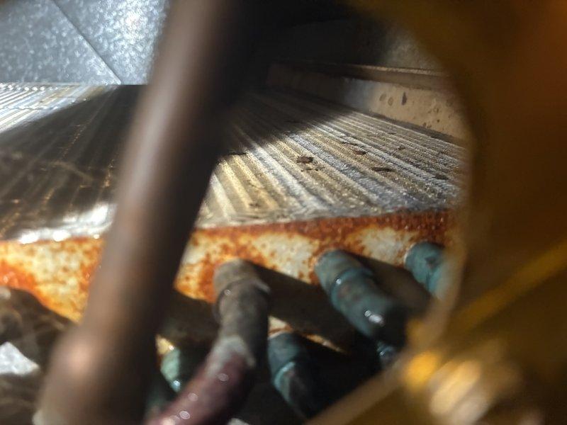 Performed preventive maintenance inspection on residential air conditioning system for established customer. Upon examination of indoor evaporator coil assembly, identified moderate to significant rust and corrosion present on metal housing components, corrugated fins, and mounting surfaces, indicating prolonged moisture exposure. Documented deterioration with photographic evidence showing oxidation patterns around connection points and along seams of ductwork. Inspected refrigerant lines, condensate drainage system, and associated mechanical components for proper operation. System functionality verified at time of service visit.