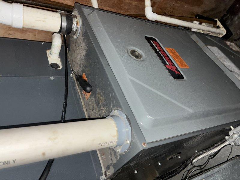 Completed standard air conditioning tune-up and system inspection on residential HVAC unit of unknown age. Accessed equipment located in attic space, verified electrical disconnect operation, and documented system components including condensate drainage lines and ductwork connections. Observed and photographed significant moisture damage, mold growth, and water intrusion issues in the mechanical equipment area requiring immediate attention and remediation.